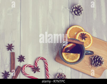 Una tazza di ceramica di riscaldamento tè con cannella e arancio su un rustico tavolo bianco. copia spazio. vista dall'alto. Foto Stock