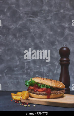 Hamburger fatti in casa con verdure fresche e Spicchi di patate. Sulla scrivania. Foto Stock