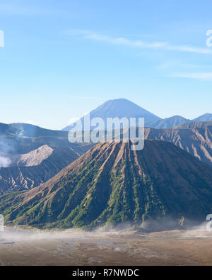 Il monte vulcano Bromo cratere erutta nella caldera, dietro il Gunung Batok, con Gunung Semeru in background, Java, Indonesia. Foto Stock