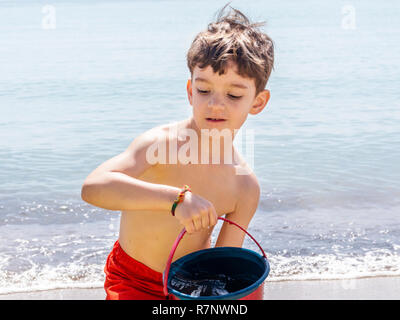 Giovane ragazzo giocando su una spiaggia in Costa Azzurra Foto Stock