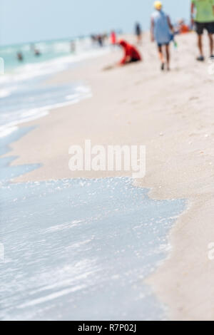 Sanibel Island, Florida, Stati Uniti d'America Bowman spiaggia con molte persone, COSTA, COSTA, sfondo bokeh, wave on shore in verticale Foto Stock