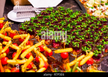 Crostini e antipasti freddi sul tavolo del buffet, carne, verdure ed erbe su un vassoio Foto Stock