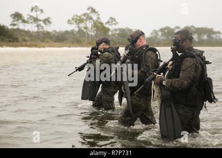 Il personale Sgt. Daniel Franklin (sinistra), team leader, Staff Sgt. Jamie Gill (centro), team leader e Sgt. George Williams (destra), assistente del team leader con forza la terza società di ricognizione, 4° Divisione Marine uscire dall'acqua durante una nave-shore diving funzionamento esercizio in Pensacola Fla., Marzo 23, 2017. L'esercizio incentrato sull'esecuzione di supporto formazione su Marina combattivo dive tattiche. La formazione deve migliorare la società la capacità di condotta inserimento specializzate e attività di estrazione. Foto Stock