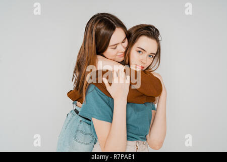 Due sorelle gemelle belle ragazze hipsters in abbigliamento casual su Foto Stock