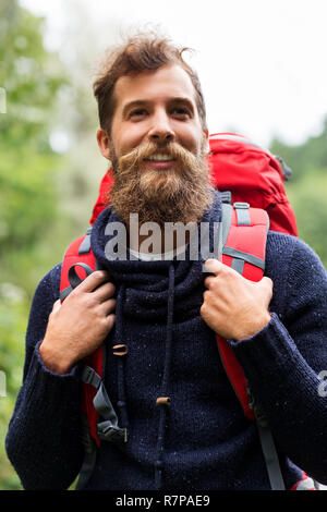 Barbuto viaggiatore con zaino in boschi Foto Stock