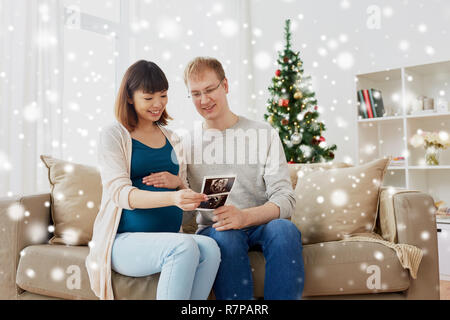 Coppia felice con immagini a ultrasuoni a natale Foto Stock