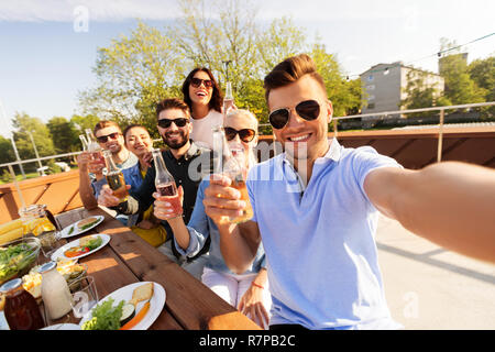 Happy amici prendendo selfie al partito sul tetto Foto Stock