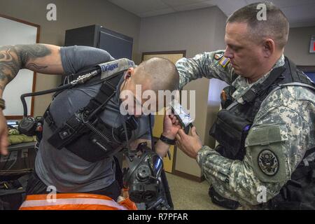 Emergency Medical Technician Sgt. 1. Classe Anthony Norrish, diritto di sciopero aiuta i membri del team personale Sgt. Nicky Lam, sia con il New Jersey Guardia Nazionale della ventunesima armi di distruzione di massa supporto Destruction-Civil Team, con la sua auto-respiratore e ri-sfiatatoio durante un esercizio di formazione con la Picatinny Arsenal dei Vigili del fuoco presso il New Jersey Homeland Defence Homeland Security Center a Picatinny Arsenal, N.J., Marzo 23, 2017. Il ventunesimo WMD-CST è una unità di snodo compreso del New Jersey e la Guardia Nazionale di soldati e aviatori la cui missione è quella di sostenere le autorità civili identificando ch Foto Stock