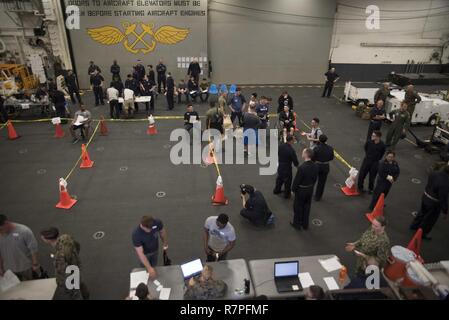 Mare delle Filippine (23 marzo 2017) Marinai e 31 Marine Expeditionary Unit (MEU) Marines a bordo di assalto anfibio nave USS Bonhomme Richard (LHD 6) effettuare una simulazione di non belligeranza operazione di evacuazione (NEO) nell'hangar bay dell'assalto anfibio nave USS Bonhomme Richard (LHD 6) come parte di un esercizio di certificazione (CERTEX). Un NEO è un esercizio in cui viene condotta per garantire comandi possono in modo rapido e completo ed efficace il compito di evacuazione non-personale combattente da regioni instabili. Bonhomme Richard, ammiraglia del Bonhomme Richard Expeditionary Strike gruppo, con avviato 31 Expe Marine Foto Stock