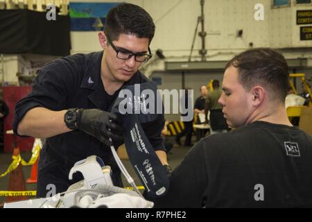 Mare delle Filippine (23 marzo 2017) Ospedale Corpsman 3rd Class Martin Salinas, assegnato all'assalto anfibio nave USS Bonhomme Richard (LHD 6), controlli a pazienti con pressione del sangue durante la simulazione di una non belligeranza operazione di evacuazione (NEO) nell'hangar bay a bordo della nave. NEO trapani sono eseguite per assicurare Navy e Marine Corps unità possono rapidamente ed efficientemente evacuare, trattare ed elaborare i cittadini americani in una situazione di emergenza se è richiesta assistenza da parte del Dipartimento di Stato. Bonhomme Richard, ammiraglia del Bonhomme Richard Expeditionary Strike gruppo, con avviato 31 Ex Marine Foto Stock