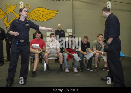 Mare delle Filippine (23 marzo 2017) velisti assegnati all'assalto anfibio nave USS Bonhomme Richard (LHD 6) partecipanti diretti durante la simulazione di una non belligeranza operazione di evacuazione (NEO) nell'hangar bay a bordo della nave. NEO trapani sono eseguite per assicurare Navy e Marine Corps unità possono rapidamente ed efficientemente evacuare, trattare ed elaborare i cittadini americani in una situazione di emergenza se è richiesta assistenza da parte del Dipartimento di Stato. Bonhomme Richard, ammiraglia del Bonhomme Richard Expeditionary Strike gruppo, con avviato 31 Marine Expeditionary Unit, è su una routine operative di pattuglia Foto Stock