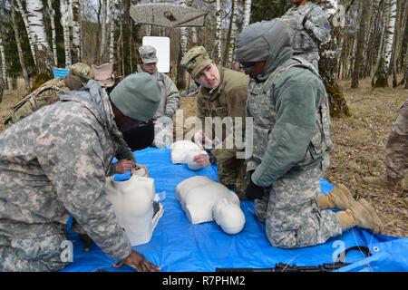 Stati Uniti Esercito Capt. Rachel Lawrence, assegnata alla sanità pubblica il comando Europa, insegna un giovane soldato come eseguire la rianimazione cardiopolmonare (RCP) come essi svolgere i diversi tipi di evacuazioni mediche, alla settima Esercito di formazione del comando di Grafenwoehr Area Formazione, Germania, 21 marzo 2017. I soldati condotta MEDEVAC formazione per sviluppare la capacità di fare squadra con i medici di volo per trasportare in modo sicuro i pazienti da un elicottero. Foto Stock