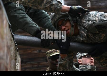 Un U.S. Soldato, assegnata alla sanità pubblica il comando Europa, muove il suo corpo attraverso un polo per ottenere su di un ostacolo durante un team-building evento al settimo Esercito di formazione del comando di Grafenwoehr area formazione Germania, 20 marzo 2017. Il team-building esercizi, che incluse fisica e intellettuale, le funzioni sono state progettate per la costruzione di unità morale e cameratismo tra i team. Foto Stock