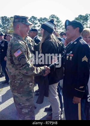 Master Sgt. Jose Barreiro, 3d U.S. Reggimento di Fanteria (la vecchia guardia), si congratula con Sgt. Brittany Sylvester-Rivera, 3d U.S. Reggimento di Fanteria (la vecchia guardia) durante un 'Turning Blue' cerimonia, Marzo 17, 2017 a Fort Benning, G.A. Sylvester-Rivera è la prima femmina di fanteria sottufficiale di reclass con successo in un undici bravo militare di combattimento specialità professionali (MOS). Foto Stock