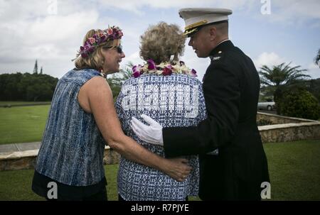 Heather Kaio, Debbie Hazelbaker e Col. Christopher D. Patton, il comandante della Marina Gruppo di aeromobili 24, attendere per elicotteri da MAG-24 per condurre un uomo mancante formazione durante la cerimonia di commemorazione per pensionati Marine Col. Vincil W. Hazelbaker, all'Hawaiian Memorial Park Cemetery il 24 marzo 2017. L'uomo mancante formazione è un'antenna salutate eseguite durante un flypast di aereo a un evento commemorativo, tipicamente in memoria di un caduto pilota. Hazelbaker era un aviatore marino che ha servito nei militari per 34 anni. Durante il suo servizio, ha volato più di 680 missioni di combattimento e orecchio Foto Stock