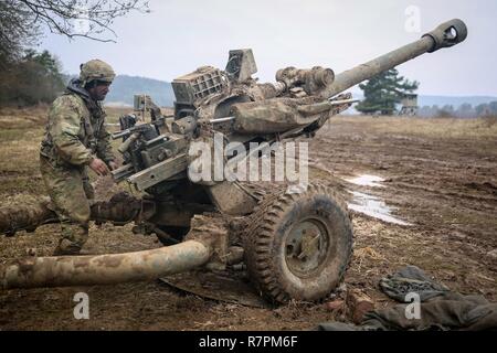 Un U.S. Soldato della società Alfa, 4° Battaglione, 319Airborne campo reggimento di artiglieria, 173rd Airborne Brigade regola un M119 105mm obice durante la conduzione di un incendio a secco esercizio durante l'esercizio Allied spirito vi al settimo Esercito di formazione del comando Hohenfels Area Formazione, Germania, 24 marzo 2017. Esercizio Allied spirito vi comprende circa 2.770 partecipanti da 12 NATO e partner per la pace delle nazioni, e degli esercizi di tattica di interoperabilità e prove di comunicazione sicura entro i membri dell alleanza e nazioni partner. Foto Stock