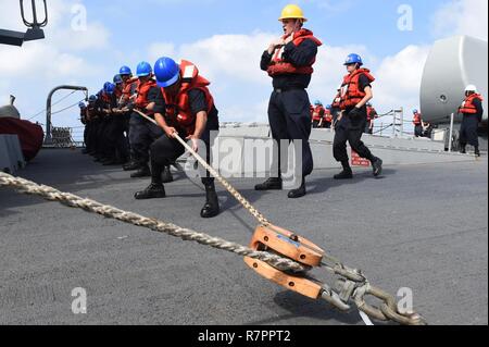 Sul mare del sud della Cina (24 marzo 2017) i marinai a bordo del distribuita Arleigh Burke-class guidato-missile destroyer USS Fitzgerald (DDG 62) heave una linea durante un rifornimento in mare. Fitzgerald è di pattuglia nel Mare della Cina del Sud il supporto di sicurezza e stabilità nella Indo-Asia-regione del Pacifico. Foto Stock
