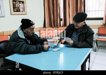 Fassouta, Israele. 10 dicembre, 2018. Gli uomini giocano a carte gli anziani del centro di giorno in Fassouta. Un villaggio e di un consiglio locale sulle pendici nord-occidentale del monte Meron nel distretto settentrionale di Israele, Fassouta è situato a soli 2 Km a sud della frontiera libanese. Credito: Nir Alon/Alamy Live News Foto Stock