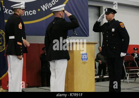 La contea di Suffolk del funzionario di polizia Matias Ferreira Marino saluta Capt. Jon Stange, il delegato per il Marine Corps stazione di reclutamento di New York, durante la premiazione presso il Suffolk County Community College 24 marzo, 2017, in Brentwood, N.Y. Ferreira è stato riconosciuto dal comandante del Marine Corps per i sacrifici compiuti e l'impegno dimostrato dai Ferreira durante il suo tempo come Marine e dal lasciando i ranghi attivi. Il comandante detta Ferreira esemplifica i valori e ethos del Marine Corps. Foto Stock