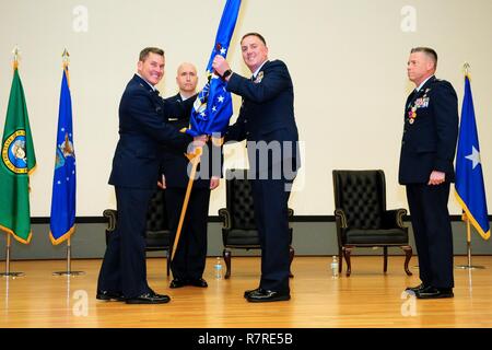 Washington Air National Guard Commander Brig. Gen. Giovanni Tuohy mani la bandiera della 194th ala dell'arrivo di Wing Commander Col. Gent gallese, come outgoing Wing Commander Col. Jeremy Horn (estrema destra) e ala comando Master Chief Sgt. Brian Wagoner guarda su nel corso di una cerimonia al teatro sempreverdi a base comune Lewis-Mccorda su aprile 1. Foto Stock