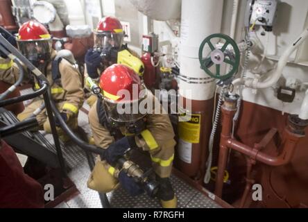 Sul mare del sud della Cina (28 marzo 2017) marinai la lotta contro un incendio simulato durante un controllo dei danni a bordo trapano Arleigh Burke-class guidato-missile destroyer USS Michael Murphy (DDG 112). Michael Murphy è su un regolarmente programmati Pacifico occidentale di implementazione con la Carl Vinson Carrier Strike gruppo come parte dell'U.S. Flotta del pacifico-led iniziativa di estendere il comando e le funzioni di controllo di Stati Uniti 3a flotta. Stati Uniti Navy portaerei strike gruppi hanno pattugliato il Indo-Asia-Pacifico regolarmente e sistematicamente per più di 70 anni. Foto Stock