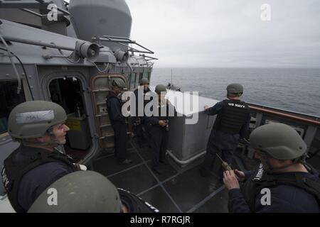 Oceano atlantico - (31 marzo 2017) - Membri della piccola azione craft i membri del team e della nave o nautiche altrimenti intelligenza fotografica esame del team di formazione condotta sul ponte di ala a bordo della USS Carney (DDG 64) durante l'esercizio comune della Warrior 17-1 Marzo 31, 2017. Carney, un Arleigh Burke-class guidato-missile distruttore, distribuita a Rota, Spagna, sta conducendo la sua pattuglia di terzi negli Stati Uniti Sesta flotta area di operazioni a sostegno degli Stati Uniti per gli interessi di sicurezza nazionali in Europa. Foto Stock