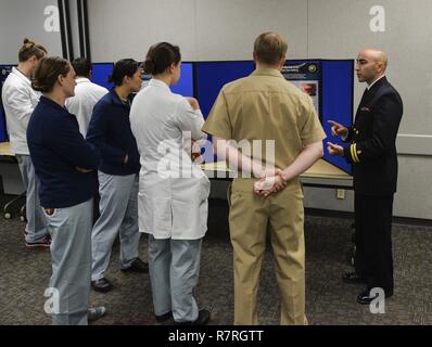 SAN DIEGO (Mar. 31, 2017) Marinai e facoltà del Naval Medical Center di San Diego (NMCSD) discutere un poster, su uvular necrosi nella cura primaria impostazione, durante la seconda edizione di partenariato Pacifico 2016 Attività Scolastica Fair a bordo NMCSD. Le attività accademiche Fair ha dato ai partecipanti la possibilità di discutere le lezioni apprese durante il partenariato del Pacifico, un disastro annuale di preparazione alla risposta di missione. Foto Stock