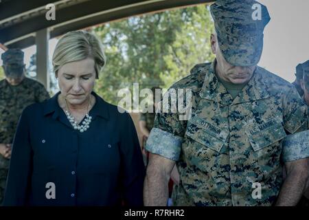 Stati Uniti Marine Brig. Gen. e la Sig.ra David A. Ottignon bow le loro teste durante l invocazione a combattere la logistica del reggimento di sfiato 1 e cerimonia di nomina a bordo Marine Corps base Camp Pendleton, California, 31 marzo 2017. La cerimonia incluso marching dei colori, passando davanti alla spada dell ufficio, presentando Sgt. Il Mag. Lonnie N. Travis il suo premio e la chiusura di commento dall'imminente e off going personale. Ottignon è il comandante generale del primo Marine Logistics Group. Foto Stock