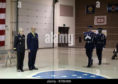 Alaska National Guard Il Mag. Gen. Laurie Hummel, l'aiutante generale e Briga. Gen. Brent Feick, direttore uscente del comune di personale per l'Alaska National Guard, guarda come la protezione di colore esegue la piegatura di bandiera cerimonia Feick durante il pensionamento di cerimonia presso la Guardia Nazionale armory su base comune Elmendorf-Richardson, Alaska, Aprile 1, 2017. Feick in pensione dopo 41 anni di servizio alla nostra nazione. Foto Stock