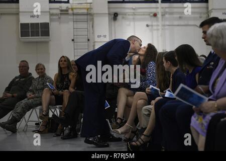 Stati Uniti Air Force Il Mag. Gen. Roger E. Williams, Jr. (sinistra), assistente del comandante, XVIII Air Force, Scott Air Force Base, Ill., dà i fiori e un bacio alla sua sposa durante la sua promozione presso il North Carolina Air National Guard Base, l'Aeroporto Internazionale Charlotte Douglas, 1 aprile 2017. Williams Gena ha ringraziato per il suo sostegno nel corso di tutta la sua carriera e per la sua dedizione alla loro famiglia. Foto Stock