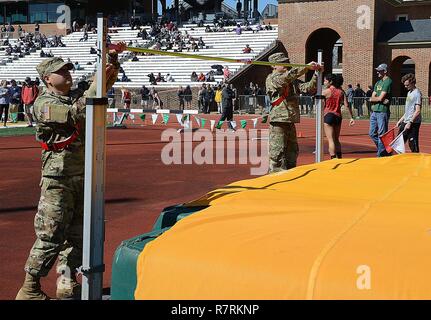 Stati Uniti Pvts dell esercito. José Casas e Alec Salazar, società di Echo, 266th Quartermaster battaglione, XXIII brigata Quartermaster avanzati di formazione dei singoli studenti, regolare l'altezza del salto in alto bar durante una pista e campo incontro presso il College of William and Mary a Williamsburg, Virginia, 1 aprile 2017. Le unità AIT soldati da Echo Co. ha supportato l'evento, che ha ospitato il 65 differenti college e università, nonché 34 high school di squadre da sei membri. Foto Stock