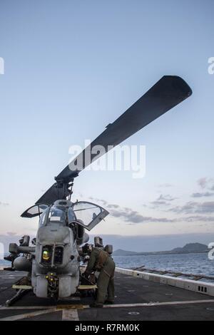 BUCKNER BAY (5 aprile 2017) Marines assegnato a mezzo marino Tiltrotor Squadron (VMM) 262 (rinforzato) condotta pre-decollo controlli su un AH-1W Super elicottero Cobra a bordo il trasporto anfibio USS dock Green Bay (LPD 20). Green Bay, parte dell'Bonhomme Richard Expeditionary Strike gruppo, con avviato 31 Marine Expeditionary Unit, è di pattuglia, operando in Indo-Asia-regione del Pacifico per migliorare la prontezza combattimento e la postura in avanti come una pronta risposta in vigore per qualsiasi tipo di emergenza. Foto Stock