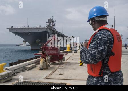 OKINAWA, in Giappone (6 aprile 2017) macchinista compagno del 3° di classe Gary Benson, da Atene, Ga., assegnato al comandante, le attività della flotta Okinawa (CFAO) operazioni portuali, esegue la movimentazione della linea funzioni come l'assalto anfibio nave USS Bonhomme Richard (LHD 6) pierside arriva alla spiaggia bianca di struttura navale di sbarcare Marines del trentunesimo Marine Expeditionary Unit. Bonhomme Richard, ammiraglia del Bonhomme Richard anfibio gruppo pronto, è su una pattuglia, operando in Indo-Asia-regione del Pacifico per migliorare la prontezza combattimento e la postura in avanti come una pronta risposta in vigore per qualsiasi tipo di emergenza. Foto Stock