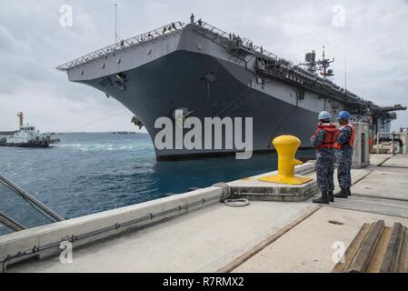 OKINAWA, in Giappone (6 aprile 2017) specialista della logistica marinaio Angel Acevedo, anteriore, da San Juan, Puerto Rico, assegnato per il trasporto anfibio USS dock Green Bay (LPD 20), e di Boatswain Mate 3° di classe Tajh Parkins, da Louisville, KY., assegnato al comandante, le attività della flotta Okinawa (CFAO) operazioni portuali, eseguire la manipolazione di linea funzioni come l'assalto anfibio nave USS Bonhomme Richard (LHD 6) pierside arriva alla spiaggia bianca di struttura navale di sbarcare Marines del trentunesimo Marine Expeditionary Unit. Bonhomme Richard, ammiraglia del Bonhomme Richard anfibio gruppo pronto, è su una pattuglia, Foto Stock