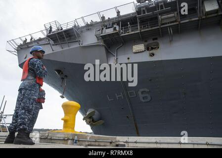 OKINAWA, in Giappone (6 aprile 2017) Boatswain compagno del 3° di classe Tajh Parkins, anteriore da Louisville, KY., assegnato al comandante, le attività della flotta Okinawa (CFAO) operazioni portuali e logistica specialista Angelo marinaio Acevedo, da San Juan, Puerto Rico, assegnato per il trasporto anfibio USS dock Green Bay (LPD 20), eseguire la manipolazione di linea funzioni come l'assalto anfibio nave USS Bonhomme Richard (LHD 6) pierside arriva alla spiaggia bianca di struttura navale di sbarcare Marines del trentunesimo Marine Expeditionary Unit. Bonhomme Richard, ammiraglia del Bonhomme Richard anfibio gruppo pronto, è su una pattuglia, Foto Stock