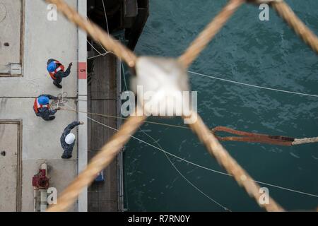 Spiaggia Bianca, Okinawa (Aprile 6, 2017) Pierside gestori di linea moor l assalto anfibio nave USS Bonhomme Richard (LHD 6) Come si arriva alla spiaggia bianca Naval Facility. Bonhomme Richard, ammiraglia del Bonhomme Richard anfibio gruppo pronto, è su una pattuglia, operando in Indo-Asia-regione del Pacifico per migliorare la prontezza combattimento e la postura in avanti come una pronta risposta in vigore per qualsiasi tipo di emergenza. Foto Stock