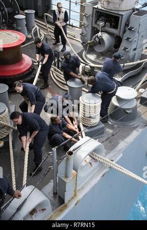 Spiaggia Bianca, Okinawa (Aprile 6, 2017) marinai gestire linee di ormeggio sul fiocco di assalto anfibio nave USS Bonhomme Richard (LHD 6) come la nave attracca pierside alla spiaggia bianca Naval Facility. Bonhomme Richard, ammiraglia del Bonhomme Richard anfibio gruppo pronto, è su una pattuglia, operando in Indo-Asia-regione del Pacifico per migliorare la prontezza combattimento e la postura in avanti come una pronta risposta in vigore per qualsiasi tipo di emergenza. Foto Stock