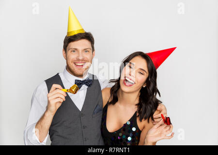 Coppia felice con party soffianti divertendosi Foto Stock