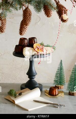 In stile tradizionale francese dessert canele torte sulla tabella di festa. Atmosfera natalizia, stile di vita, una lettera a Babbo Natale. Il decor delle loro abete b Foto Stock