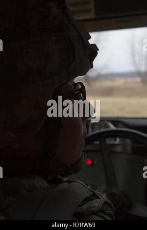 US Army Spc. Jessica Taylor, un affari civili uno specialista con la 364 gli affari civili brigata, 351A gli affari civili del comando, manovre un Humvee durante un esercizio di cottura come parte del funzionamento freddo Acciaio a Fort McCoy, Wis., il 02 aprile 2017. La 351CACOM è responsabile per operazioni strategiche attraverso la tattica degli affari civili sostegno da parte di tutti gli Stati Uniti Pacifico Comando area di responsabilità. Funzionamento a freddo è di acciaio negli Stati Uniti La riserva di esercito di equipaggio è servita la qualifica di armi ed esercizio di convalida per garantire che l'America dell'esercito di unità di riserva e soldati sono addestrati e pronto per la distribuzione con breve preavviso Foto Stock