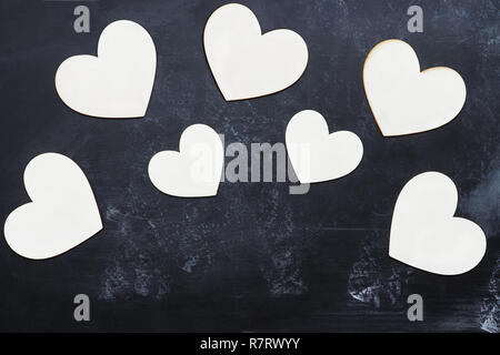 Vista superiore del legno e di tagliare fuori il giorno di San Valentino cuori su una lavagna rustico con camera per copiare lo spazio. Foto Stock