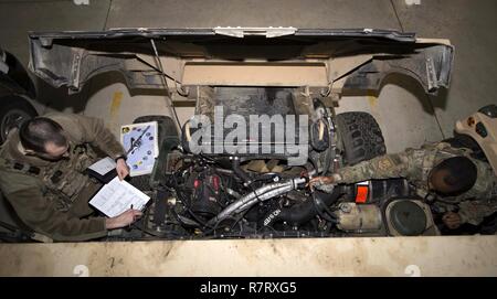 Senior Airman Michael Ripple, 791st Missile delle forze di sicurezza risposta squadron leader di forza e Staff Sgt. Calvin Smith, 91Missile forza di sicurezza volo squadrone controller di sicurezza, ispezionare il motore di un Humvee a Minot Air Force Base, N.D., Marzo 28, 2017. Per garantire una longevità di veicoli, aviatori esegue un controllo approfondito prima di andare al campo. Foto Stock