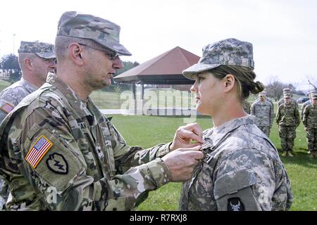 Brig. Gen. Steve Altman, vice comandante generale di manovra, Iowa Guardia nazionale, perni di Iowa Guardia Nazionale medaglia al Merito sul SPC. Lauren E. Kopetzky, un soldato da società C, 224th ingegnere vigili del Battaglione, Iowa esercito Guardia nazionale in base a Cedar Rapids, Iowa, nel corso di una cerimonia presso il Camp Dodge manovra comune centro di formazione, in Johnston, Iowa. Kopetzky è stato riconosciuto per la fornitura di aiuti a una vittima di ripresa in Ames, Iowa, il 9 agosto 2016. Foto Stock