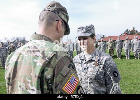 Spc. Lauren E. Kopetzky, una società C, 224th ingegnere vigili del Battaglione, Iowa l esercito nazionale soldato di guardia, basato in Cedar Rapids, Iowa, riceve l'Iowa Guardia Nazionale medaglia al Merito da Briga. Gen. Steve Altman, vice comandante generale di manovra, Iowa Guardia Nazionale, il 9 aprile 2017, nel corso di una cerimonia presso il Camp Dodge manovra comune centro di formazione, in Johnston, Iowa. Kopetzky è stato riconosciuto per la fornitura di aiuti a una vittima di ripresa in Ames, Iowa, il 9 agosto 2016. Foto Stock