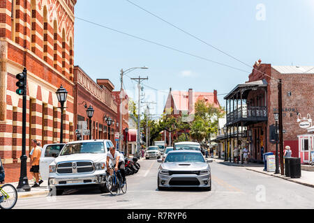 Key West, Stati Uniti d'America - 1 Maggio 2018: Duval Street architettura con vecchio First National Bank Building, gente in bicicletta sulla strada in Florida City travel, s Foto Stock