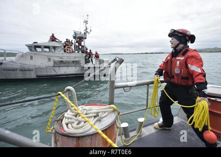 Posted to Coast Guard bussola da Diana Sherbs, Martedì, 30 maggio 2017 Scritto da Petty Officer di terza classe Sarah Wilson --- marinaio Julia Harris segue il suo supervisore attentamente le istruzioni del: il coniglio fuoriesce dal foro, intorno all'albero e torna verso il basso nel foro di coniglio. Con un solcato brow, lei ripete il codice mnemonico lentamente come lei torsioni e piega e avvolge la linea attorno a sé e tira l'estremità stretta. Ella mostra il suo capolavoro per il resto dell'equipaggio. Come ognuno dà il suo cenno di approvazione, sorride. Se il tessuto del marinaio erano fatte di nodi, forse sarebbe t Foto Stock