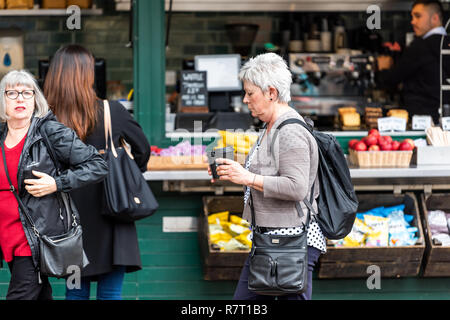 London, Regno Unito - 12 Settembre 2018: Uomini Donne acquisto di tè o caffè al mattino portando tazze per andare più veloce del contatore fuori strada al cafe nel Regno Unito Foto Stock