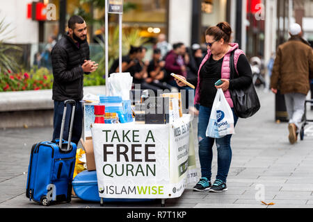 London, Regno Unito - 12 Settembre 2018: le persone felici donna e uomo da libero Quaran Islam religione stand sul marciapiede street, shopping a SoHo Foto Stock