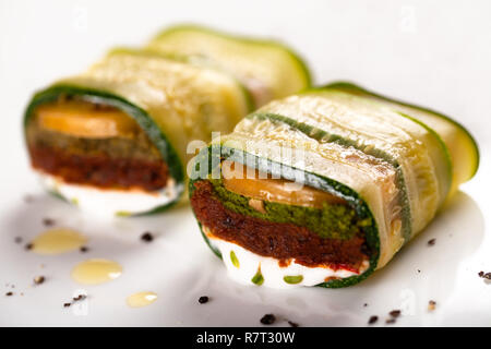 Zucchine vegana lasagne rotoli sulla piastra bianca al ristorante vegetariano Foto Stock