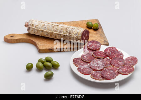 Tagliere con fette di salame e olive Foto Stock